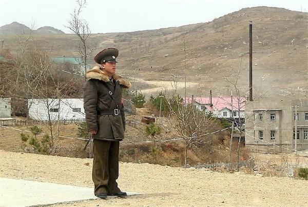 在通往罗先市的元汀里口岸附近，一位朝鲜军人站在路旁目视远方。